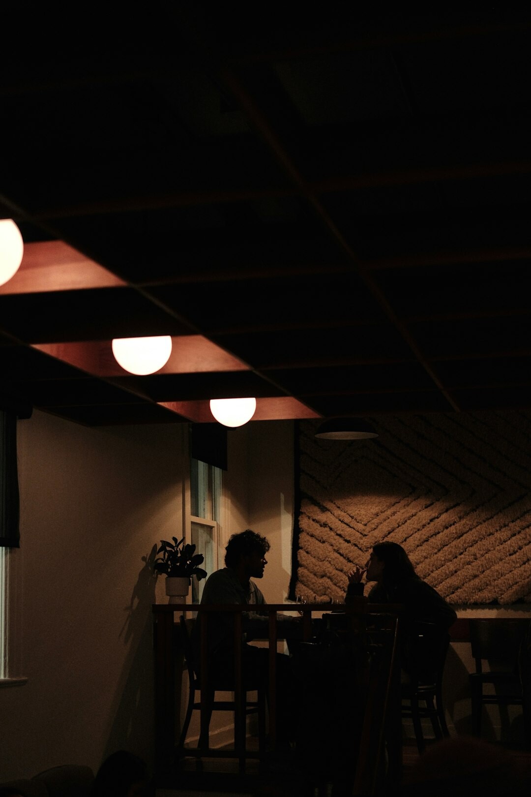 Group of professionals in a dim lit workshop discussion around a table