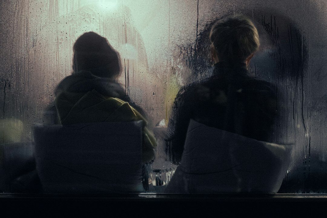 Two colleagues discussing printed documents in low light